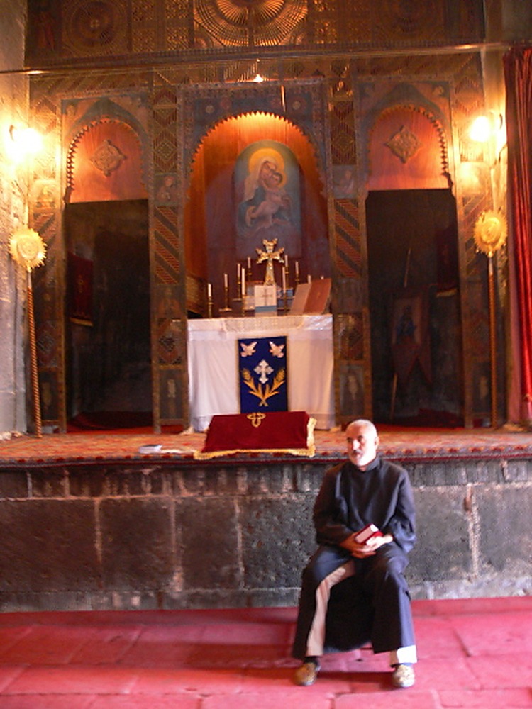 Monk near a historic church overlooking Lake Sevan in Armenia