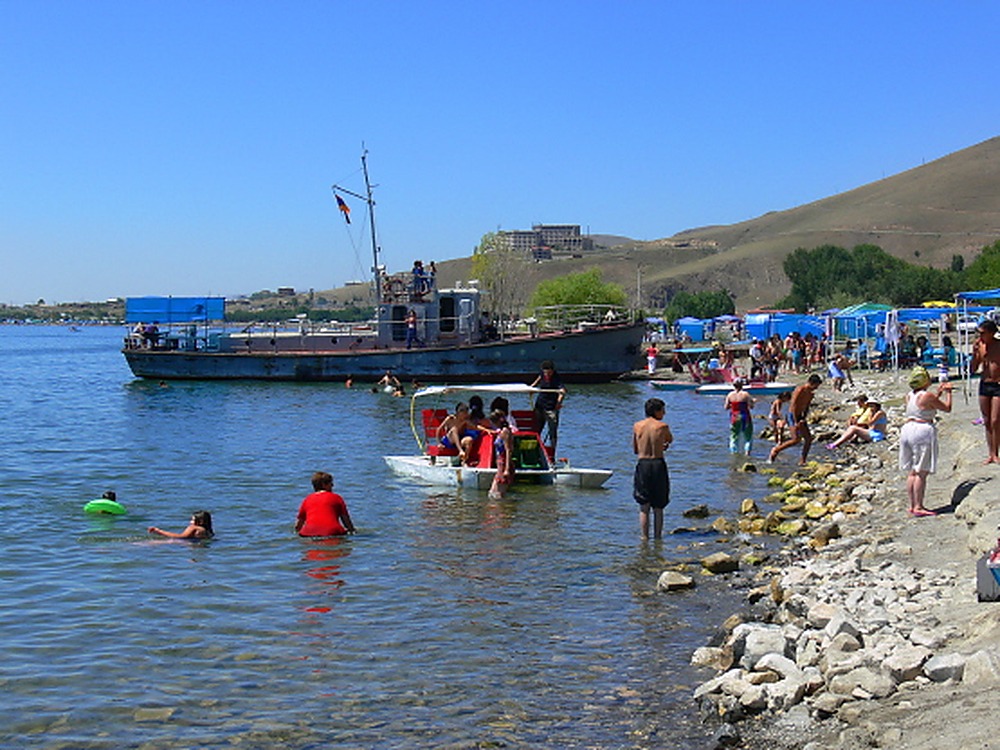 People swimming along the shore of Lake Sevan in Armenia