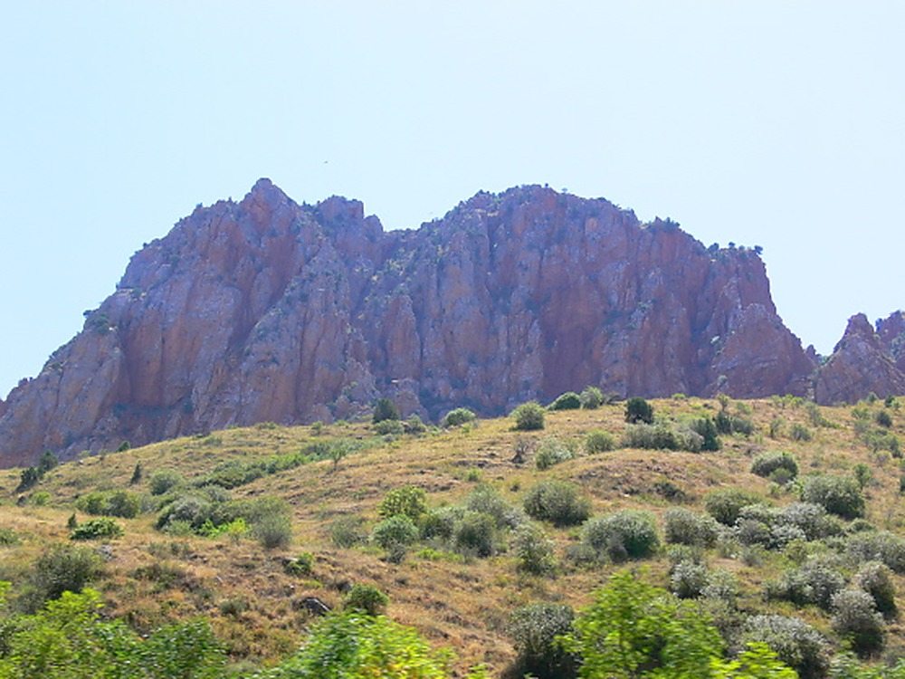 Orange cliffs and green vegetation in a rocky Armenian valley