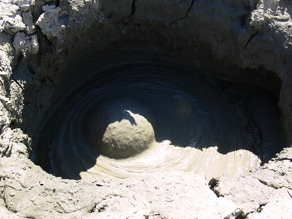 Close view into the crater of a bubbling mud volcano in Azerbaijan