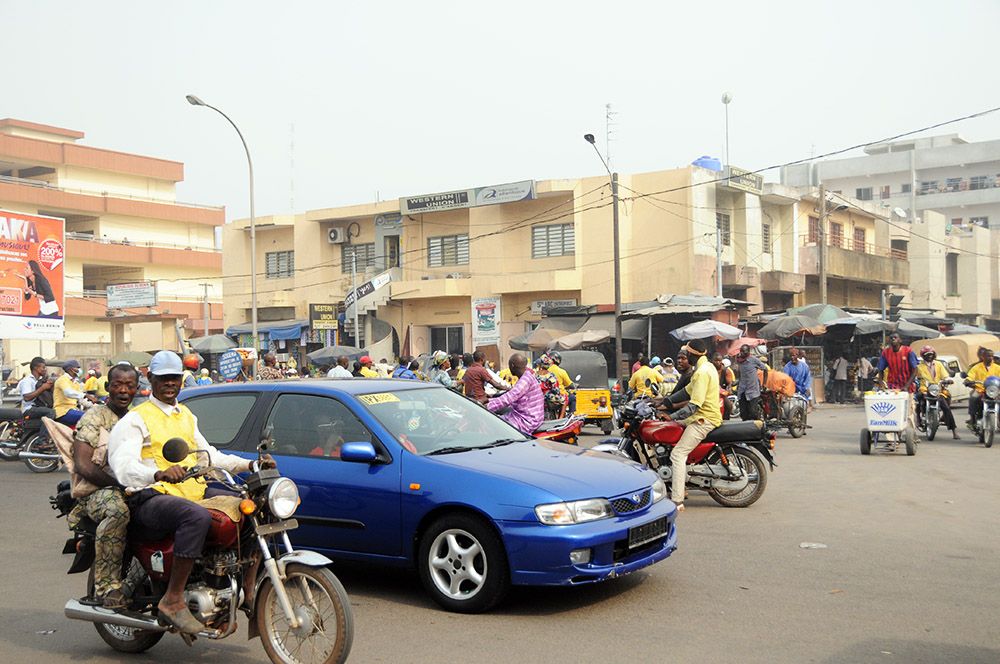 Motorcycle taxi driver wearing a yellow vest in Cotonou, Benin