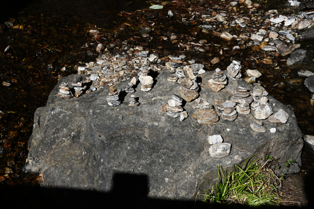 Buddhist tsa-tsas placed among rocks along the Tiger's Nest trail