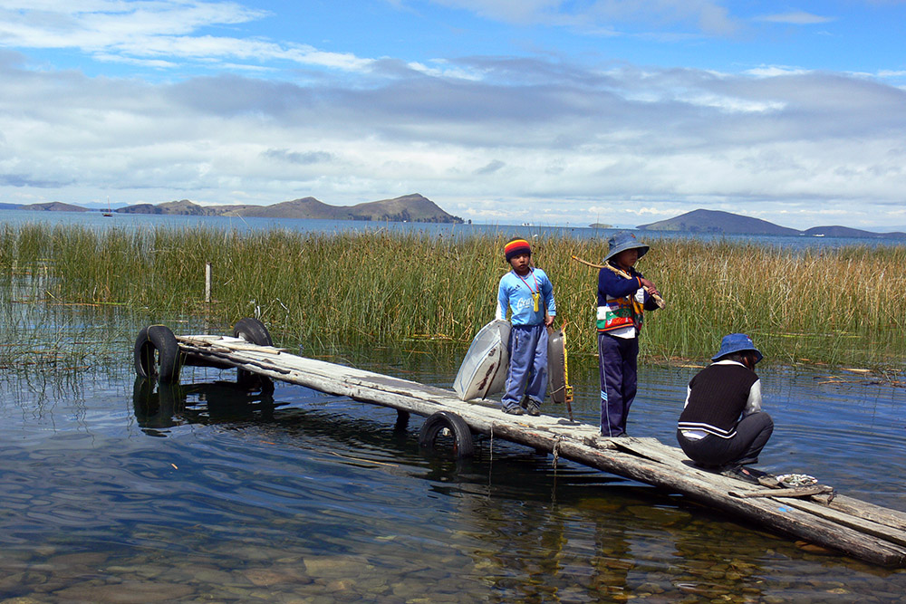 Children fishing along the shore of Lake Titicaca