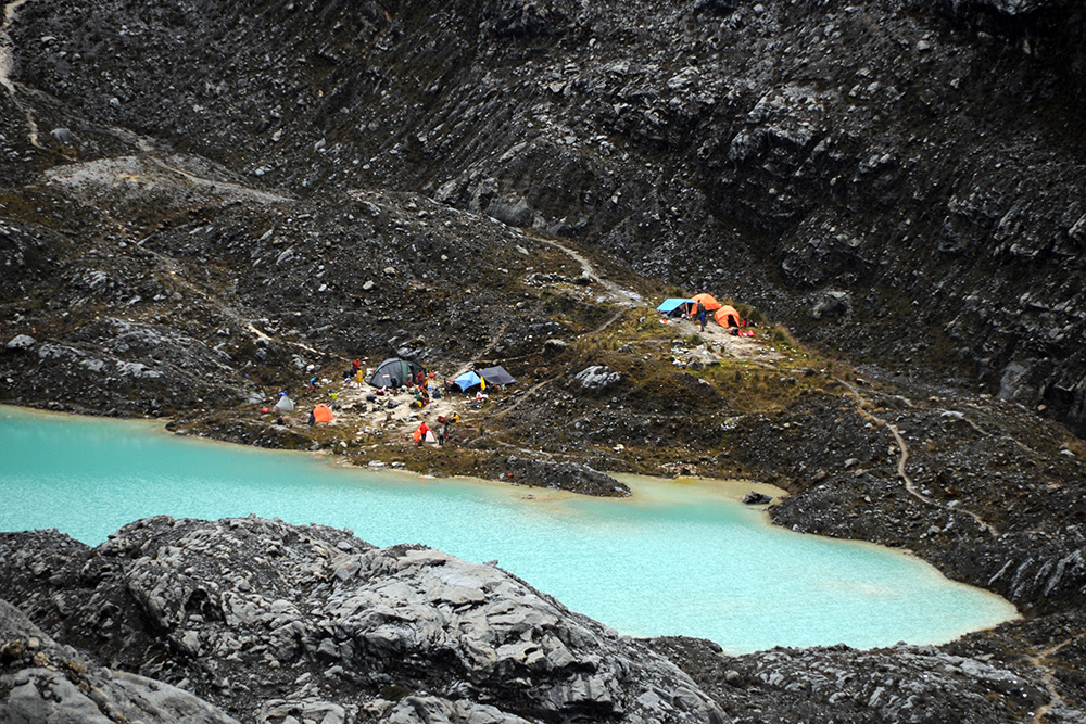 Camp V and turquoise lake at the base of Carstensz Pyramid