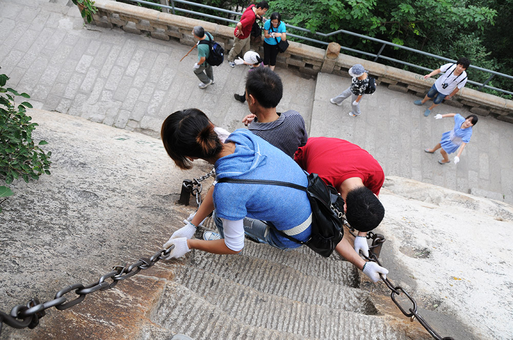 People descending the steep stairs of Mount Huashan