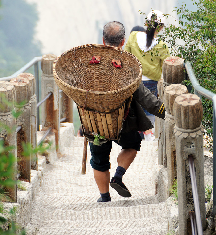 Porter carrying supplies high on Mount Huashan