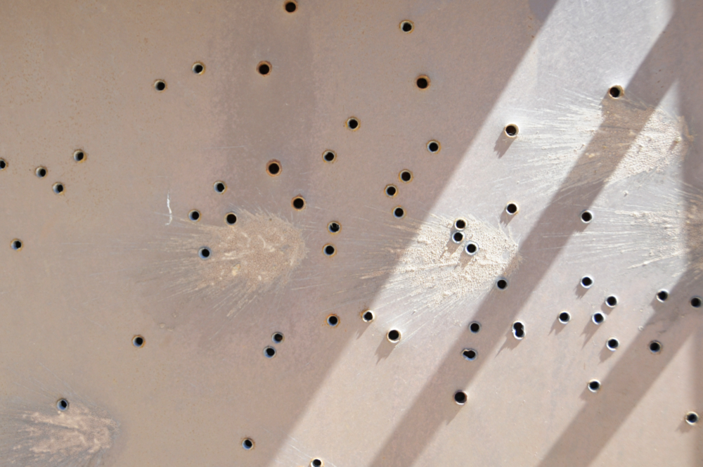 Bullet-damaged sign near Little Book Cliffs, Colorado