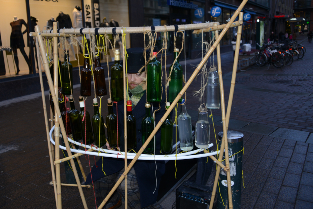 Street musician playing music with glass bottles in Helsinki
