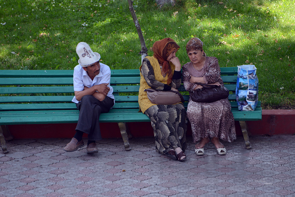 People relaxing along a street in Osh