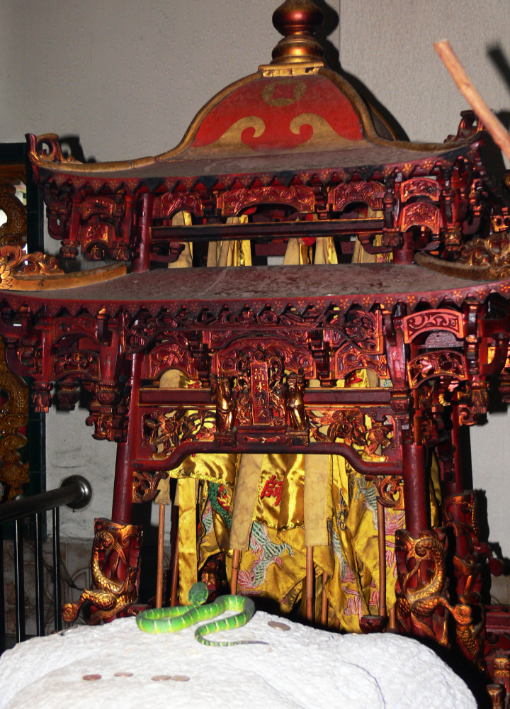 Snake near an altar at the Snake Temple in Penang
