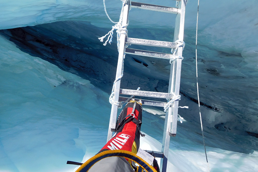 Crossing a ladder over a crevasse in the Khumbu Icefall