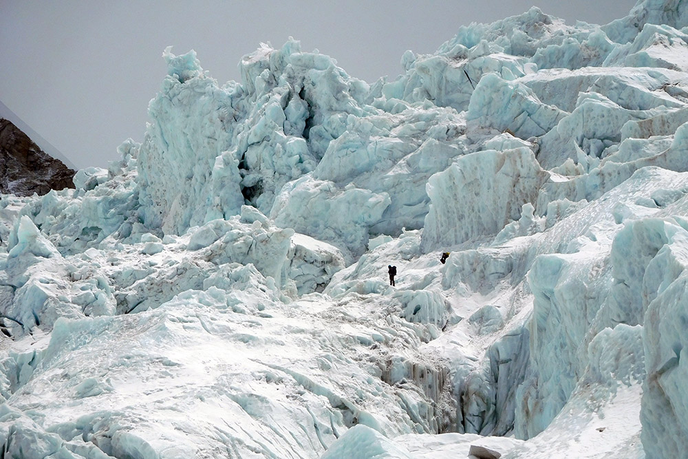 Climbers beneath giant seracs in the Khumbu Icefall