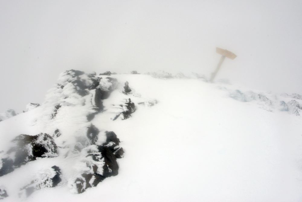 Humphreys Peak summit sign covered in winter ice and fog