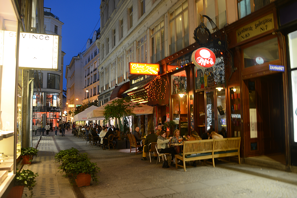 Restaurants along a narrow street in Vienna at night