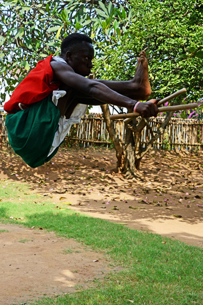Traditional Burundi drummer performing a high jump