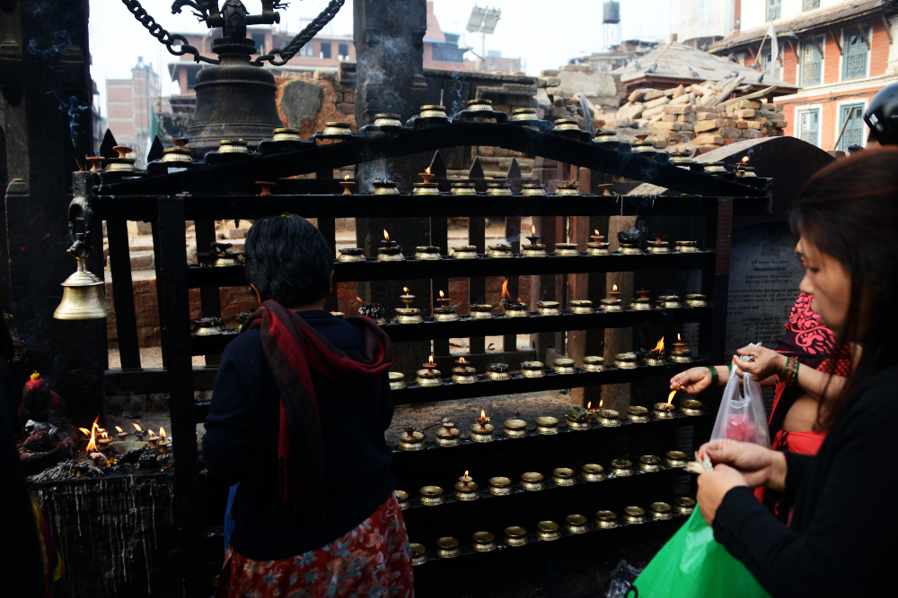 Religious offerings and prayer candles at a shrine in Kathmandu