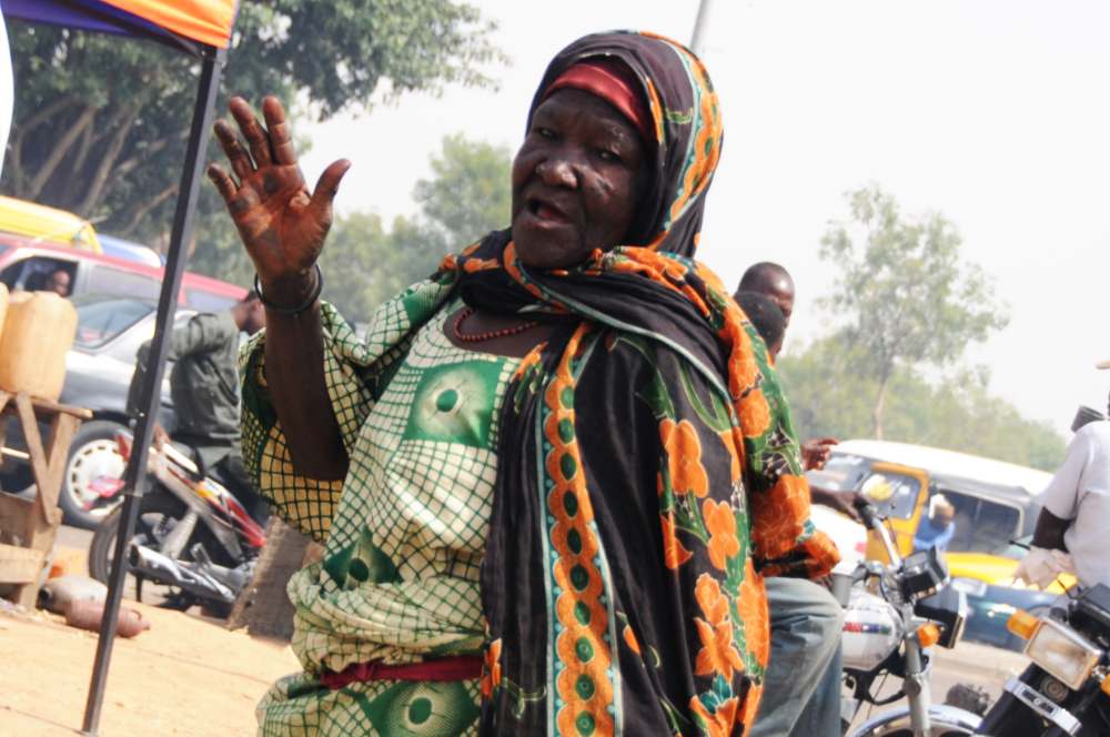 Woman beside a busy intersection in Kano Nigeria