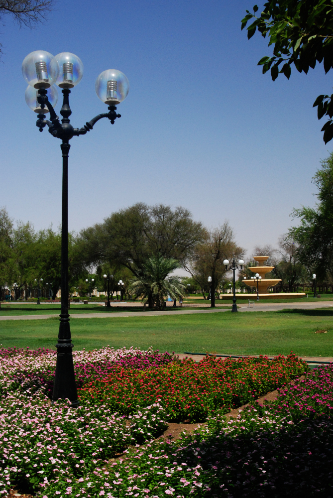 Landscaped gardens and palm trees at Hili Archaeological Park in Al Ain